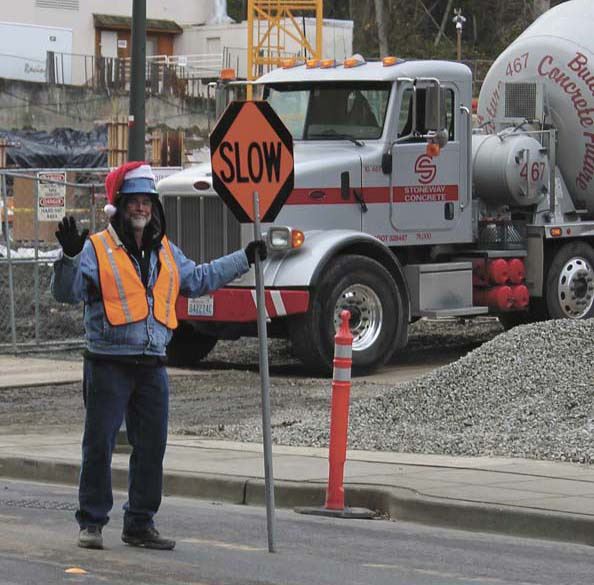 Synergy flagger Robert Flemming waves to drivers who pass in front of the Aviara construction project on 76th Ave. S.E.
