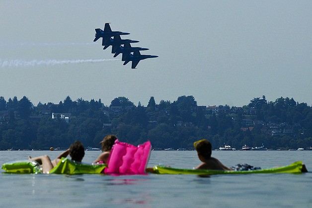 Spectators watch the U.S. Navy Blue Angels airshow practice from inflatable floats at Slater Park on Mercer Island on Thursday afternoon on August 5