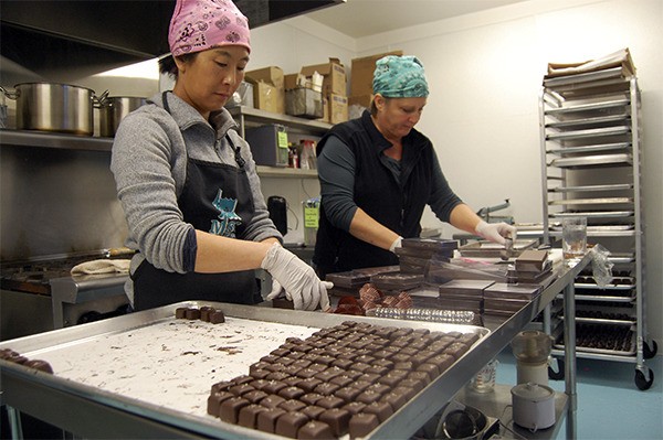 Ann Peterson and neighbor Jeannie Cho work on putting together boxes of sea salt caramels to fill orders for Valentine’s Day.