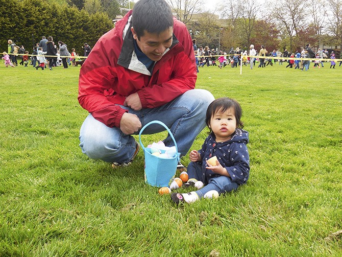 One-year-old Bailey sits down to count her eggs with the help of her dad