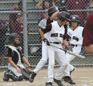 Members of the Mercer Island LIttle League All Stars 9-10 team congratulate a team member after hitting a two run home run in the bottom of the first inning during Monday night's district championship game against Sammamish.