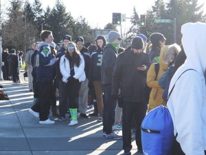 More than 400 people waited in line at the Mercer Island Park-and-Ride for a bus to take them to downtown Seattle and the parade to honor the Seattle Seahawks.