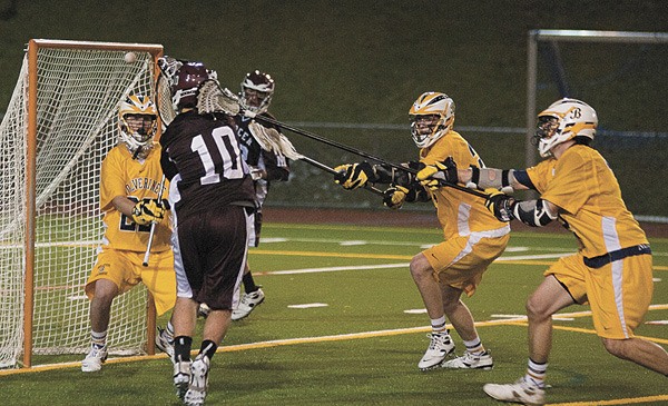 Mercer Island attackman Matt Shields (maroon #10) fires a shot past Bellevue goaltender Austin Boyd Thursday night in boys Division I high school lacrosse action at Bellevue High School. The Islanders upset the defending state champion Wolverines 8 - 6 in their only regular season meeting of the season.
