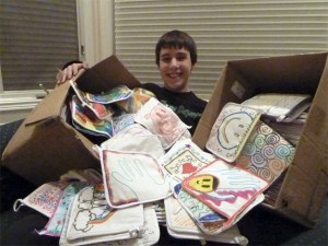 Benjamin Zawadzki shows off the potholders made by members of the Pinwheel Region United Synagogue Youth for Darfur refugees to handle hot solar cookers. The cookers take the place of outdoor fires