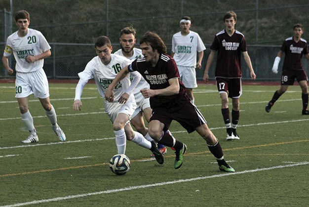 Mercer Island's Ryan Hill charges past Liberty's Tyler Jensen (16) during the first half of their 3A KingCo contest Wednesday