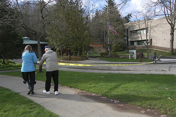 Members of the Concerned Citizens for Mercer Island Parks use caution tape and balloons to estimate the size of the planned MICA building.