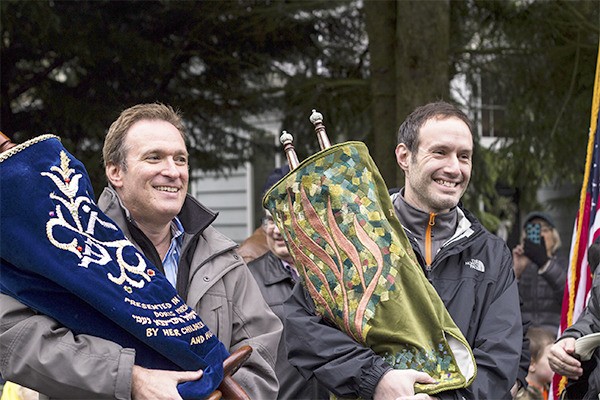 Jon Newman and Aaron Sandorffy parade with Congregation Shevet Achim’s two Torahs to the synagogue’s new home in the former Christian Science Church on Island Crest Way.