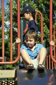 A Mercer Island boy pauses at the top of the slide in the Mercerdale Park playground on Friday afternoon