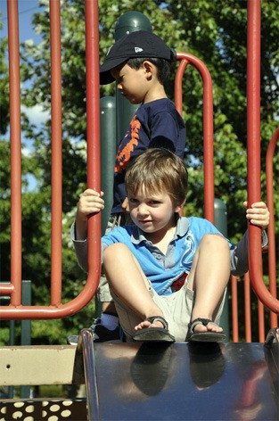 A Mercer Island boy pauses at the top of the slide in the Mercerdale Park playground on Friday afternoon