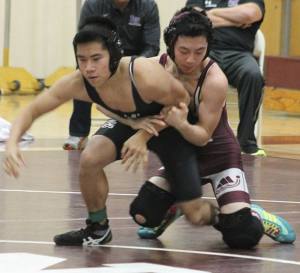 Mercer Island's Taylan Yuasa brings down Lake Washington's Hau Nguyen Wednesday