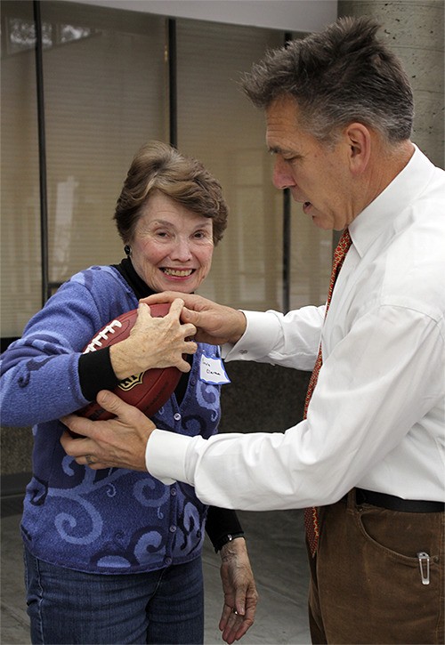 Former Seattle Seahawks quarterback and Island resident Jim Zorn adjusts Carole Clarke’s hold on the ball.
