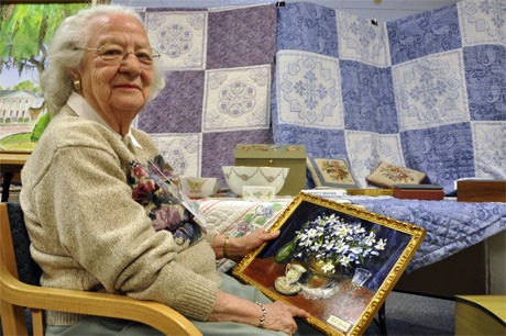 Nancy Mayes holds one of her oil paintings