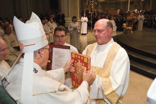 Mike Penney/Special to the Reporter McDonald receives a Book of Gospels from Archbishop Alex Brunett during the Mass of Ordination of Deacons last Saturday.