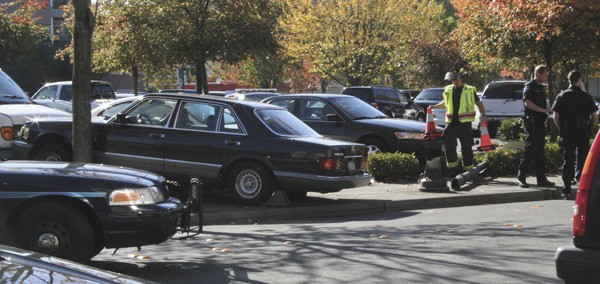 Members of the Mercer Island Police Department work through the scene of a car accident on Tuesday afternoon on S.E. 28th Street in front of QFC and Noah's. The driver of the Mercedes Benz appeared to have tried to avoid sideswipping another vehicle
