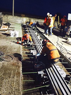Crews replace part of one of the huge expansion joints on I-90 at the East Channel Bridge on Sunday morning.