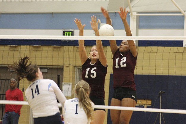 Mercer Island's Olivia Hughes (15) and Jemma Yeadon (12) block a spike by Interlake's Erin Brown (14) Wednesday night at Interlake High School. The Islanders beat the Saints