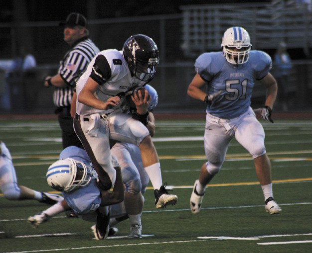 Mercer Island’s Brian Higgins (8) gets dragged down by Interlake’s Evan Turman (5) during the Islanders win at Interlake on Friday