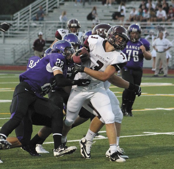 Mercer Island's Matt Orehek tries to pull free of the Lake Washington defense during the Islanders win over the Kangs on Friday