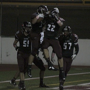 Mercer Island's David Emanuels (left) and Jack Counihan (22) celebrate Emanuels' first quarter touchdown against Interlake Friday