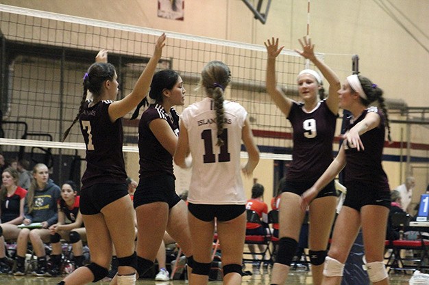 Mercer Island volleyball celebrates a block during the third set of Thursday's district match against Ballard at Juanita High School. The Islanders won