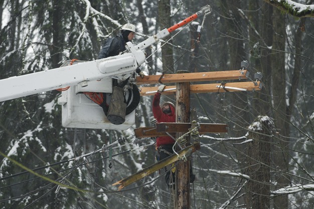 Crews work to repair power lines at 53rd Place SE and East Mercer Way on Mercer Island on Friday afternoon
