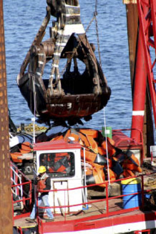 A Mason Construction crane goes to work pulling up debris from the bottom of Lake Washington as part of the 2009-2010 Sewer Lake Line project. Work on the project began last Thursday. According to project manager Anne Tonella-Howe