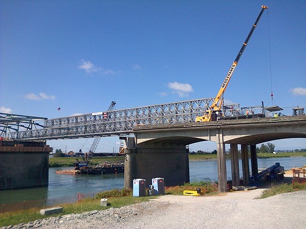 Crews construct the steel framework on the first of two temporary bridge spans designed to close the gap in the Interstate 5 Skagit River bridge.