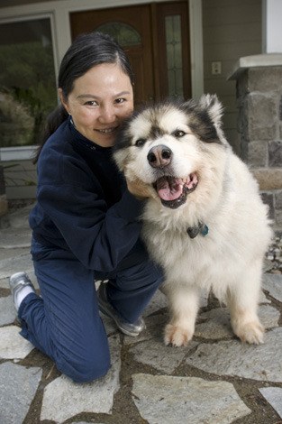 Islander Min Tibbs hangs on tight to the family dog