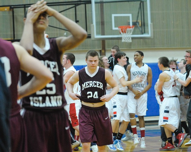The Islanders walk off the court as Kennedy Catholic celebrates the win during 3A state regional play at Rogers High School in Puyallup on Friday. Mercer Island lost 73-67.