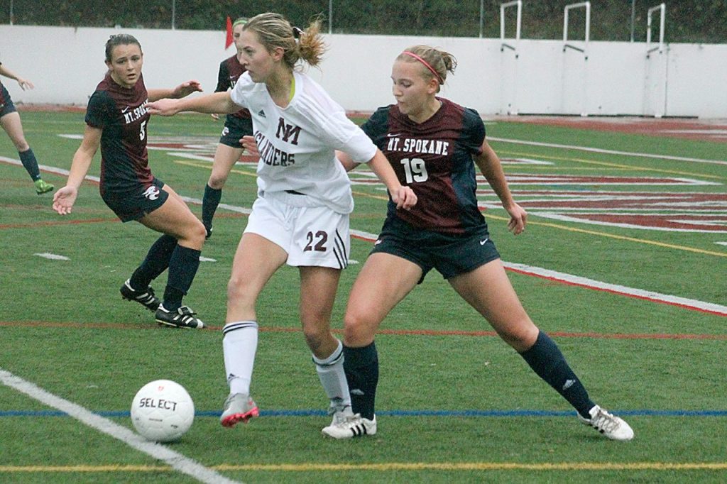 Mercer Island forward Nicole Mandt (22) fights off Mt. Spokane defender Emily Hahn during the Islanders&rsquo; winner-to-state matchup against the Wildcats Saturday at Islander Stadium. Mercer Island won 2-0. Joe Livarchik/staff photo.