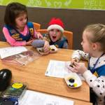 Kindergartners and Girl Scout Daisies Grace Zahler, Lucy Sternberg and Milana Jaeger try different colored foods at New Seasons on Dec. 5 as part of an &ldquo;eat the rainbow&rdquo; challenge to earn their &ldquo;courageous and strong&rdquo; petal. Photo courtesy of Ashley Sternberg