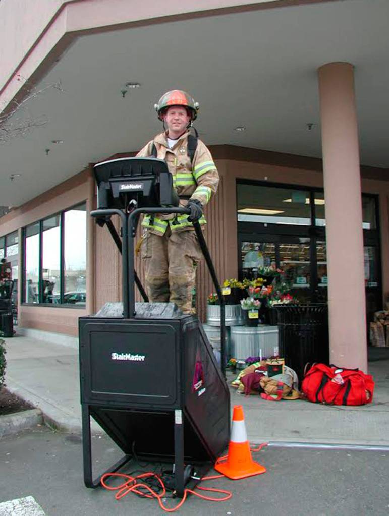 Mercer Island firefighter Trever Kissel climbs a Stairmaster in front of QFC as part of the department&rsquo;s fundraising efforts for the Scott Firefighter Stairclimb. Photo courtesy of MIFD