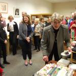 Former Chamber of Commerce Executive Director Terry Moreman cuts her cake at a March 9 reception while chamber board members and other attendees look on. Katie Metzger/staff photos