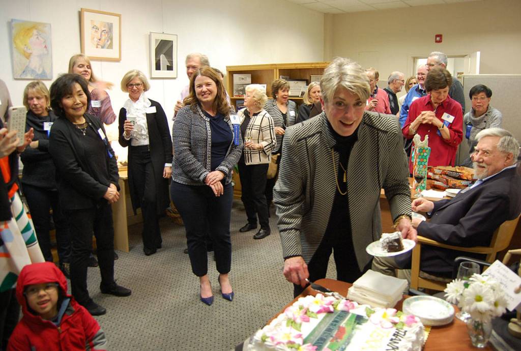 Former Chamber of Commerce Executive Director Terry Moreman cuts her cake at a March 9 reception while chamber board members and other attendees look on. Katie Metzger/staff photos