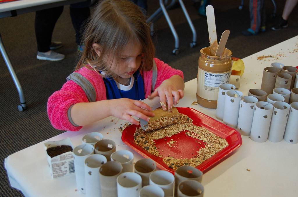 Zoe Hartman, a 3-year-old Islander, makes a bird feeder at Saturday&rsquo;s sustainability fair. Katie Metzger/staff photo