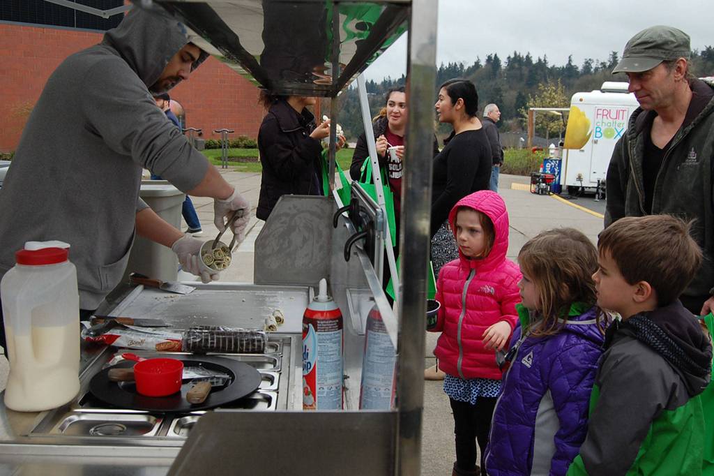 Kids watch as their Igloo Rolls ice cream is made in front of them at Saturday&rsquo;s Leap for Green fair. Katie Metzger/staff photo
