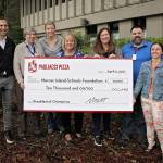 Matt Galvin presents a check to the Schools Foundation on behalf of Pagliacci Pizza. Photo courtesy of Michelle Galvin