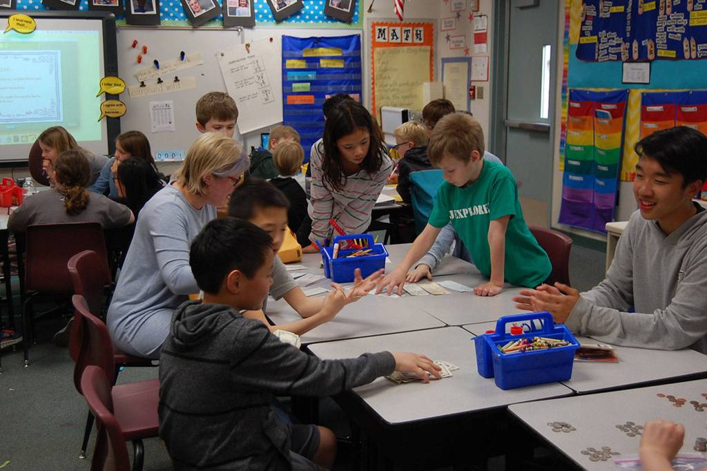 Members of the K-Kids &ldquo;finance team&rdquo; count the money raised from the bracelet fundraiser. They brought in about $5,000. Katie Metzger/staff photo