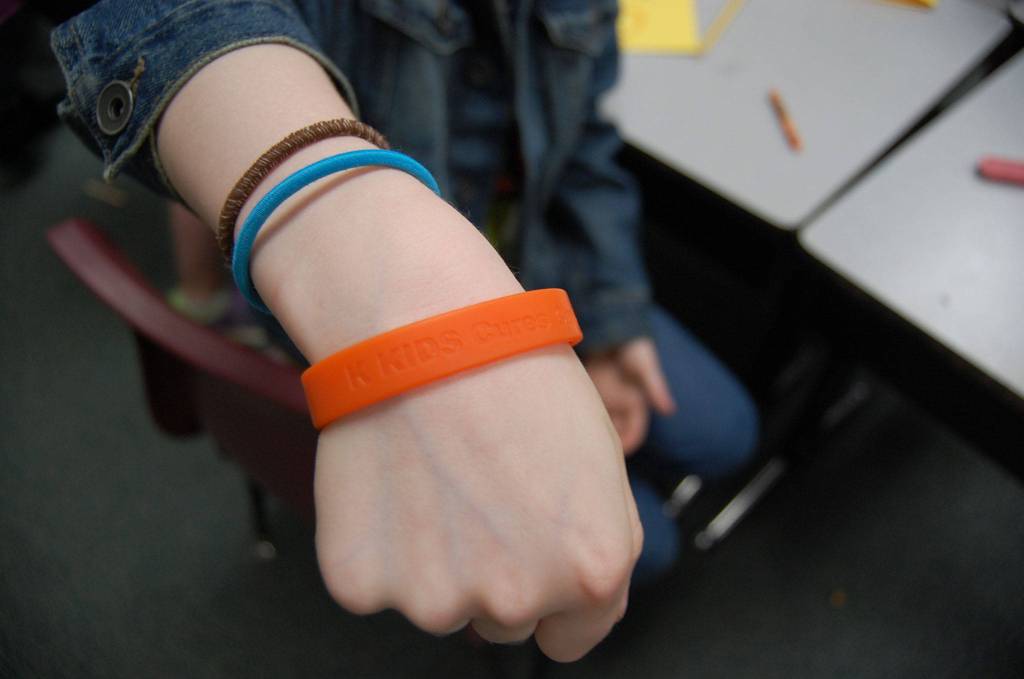 The bracelets have &ldquo;K-Kids Cure Cancer&rdquo; printed on them. Katie Metzger/staff photo
