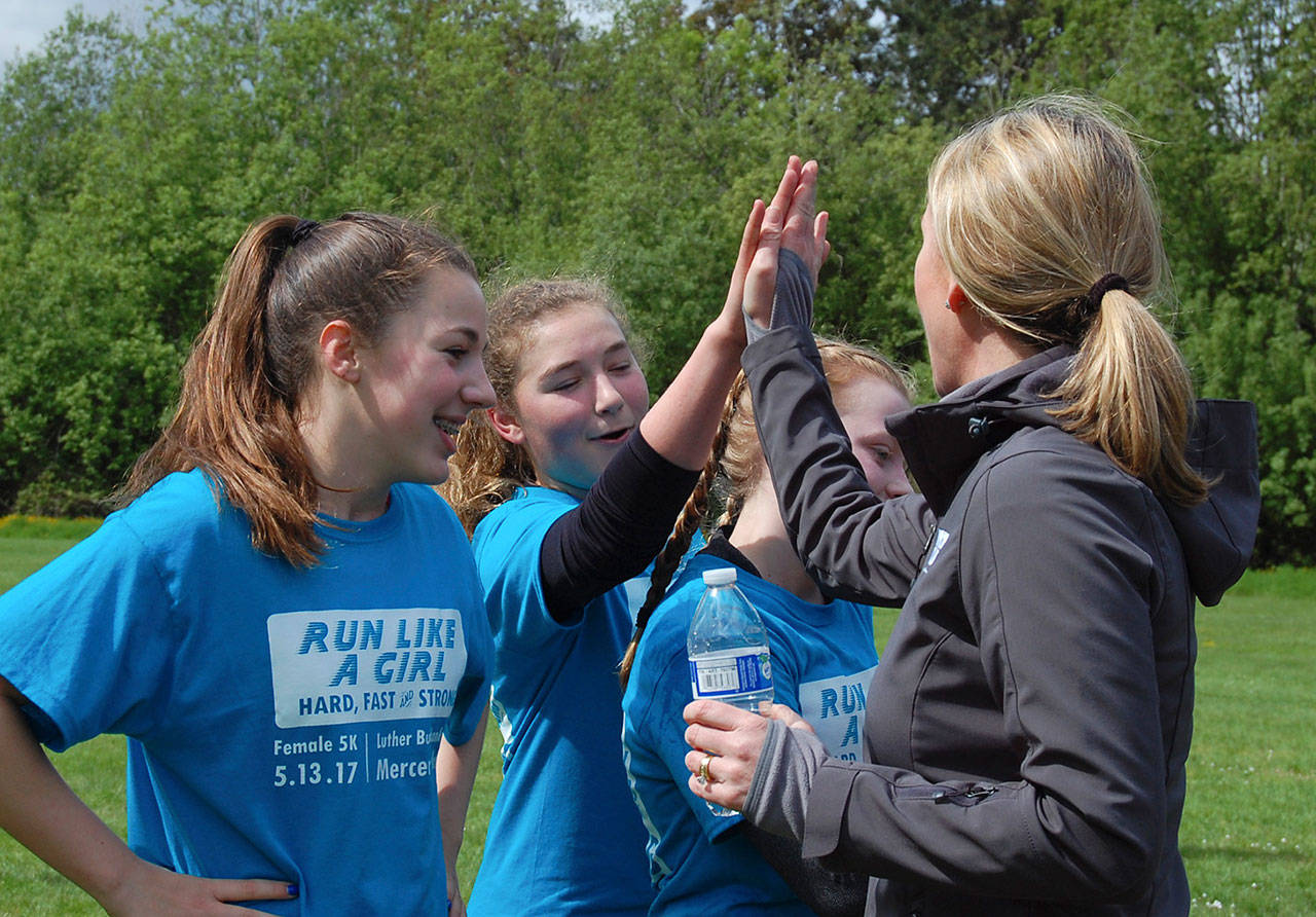 Mercer Island&rsquo;s Recreation Superintendent Diane Mortenson high fives finishers of the Run Like a Girl 5K on May 13. Katie Metzger/staff photo