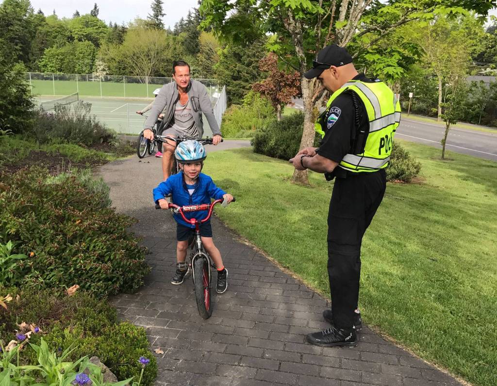 Mercer Island police officer Scott Hyderkhan helps kids get to West Mercer Elementary safely for Bike to School Day on May 10. Photo courtesy of MIPD