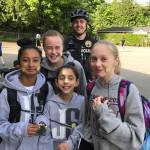 Sgt. Robb Kramp poses with four young ladies adorned with stickers for Bike to School Day on May 10. Photo courtesy of MIPD
