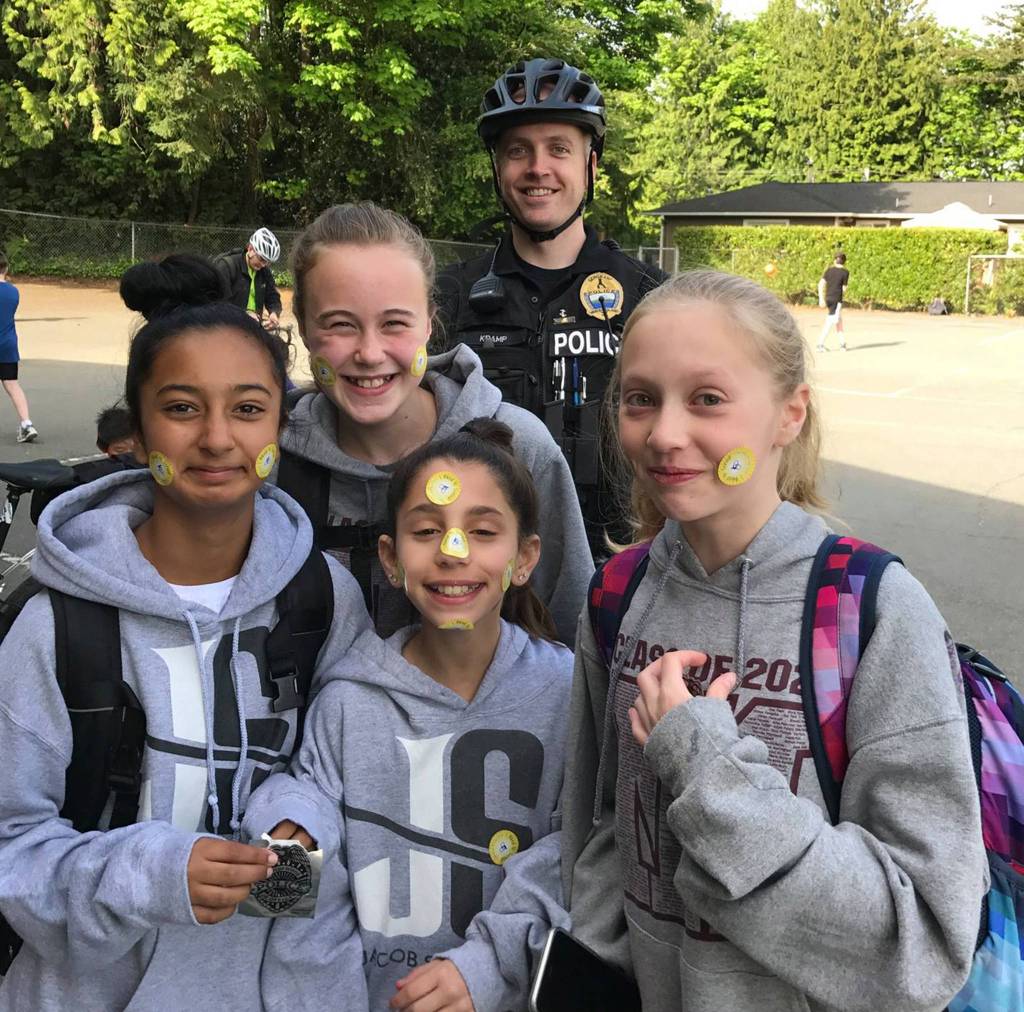 Sgt. Robb Kramp poses with four young ladies adorned with stickers for Bike to School Day on May 10. Photo courtesy of MIPD