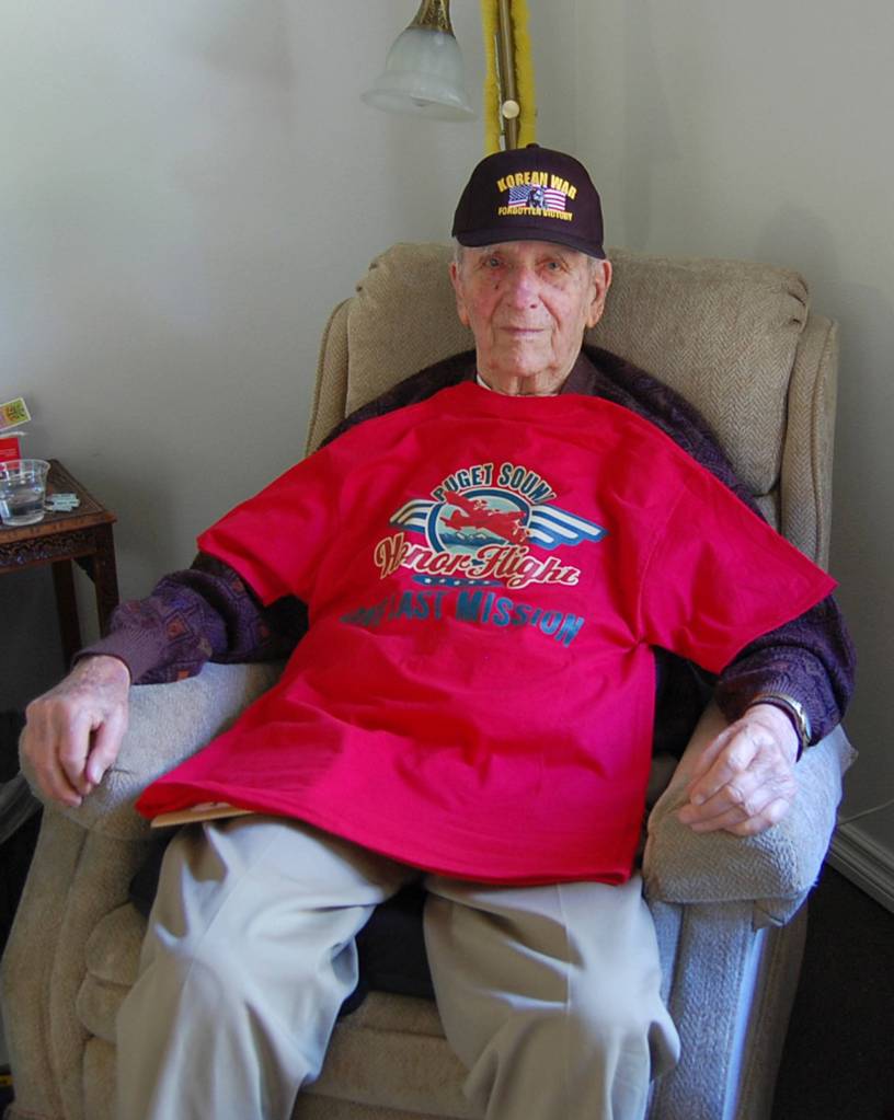 John Kneepkens shows off his T-shirt and hat from his Honor Flight trip in his room at Covenant Shores on May 23. Kneepkens, 97, served in Army hospitals during World War II, and stayed in the military for 20 years after that. Katie Metzger/staff photo