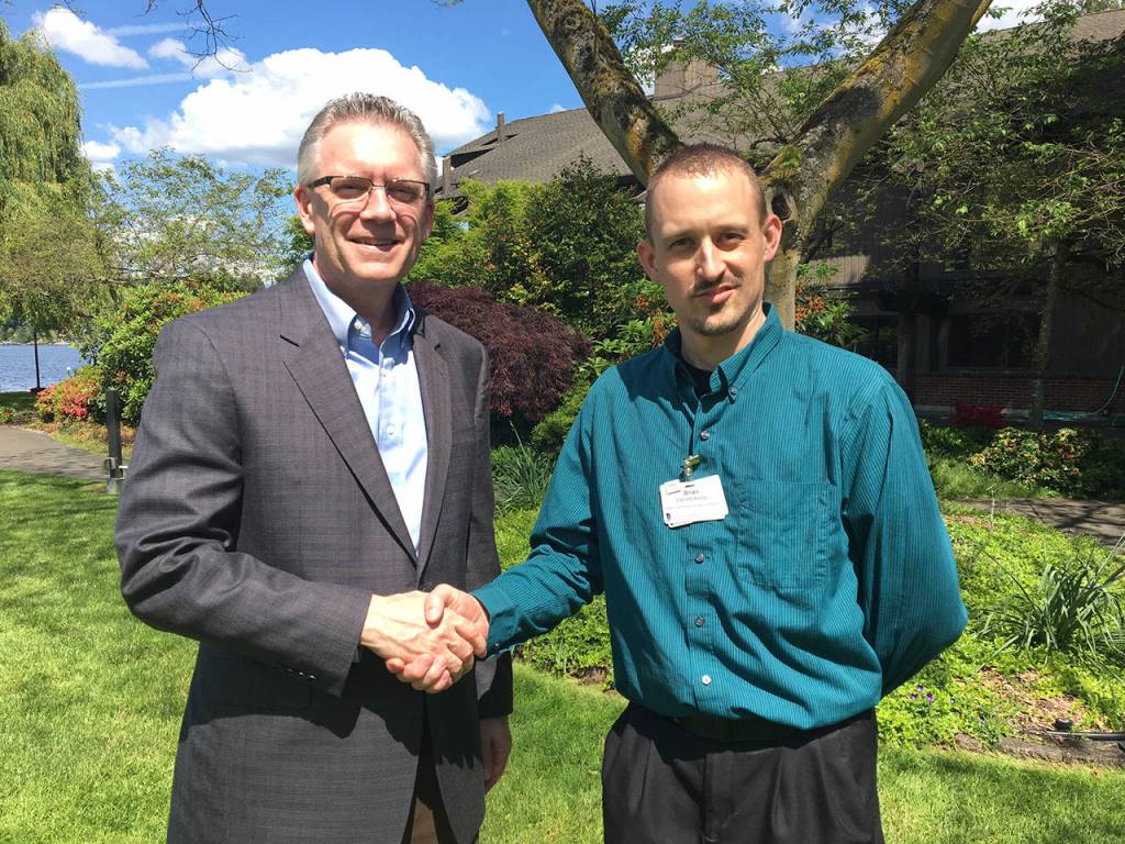 Covenant Shores Executive Director Bruce Erickson congratulates employee Brian Vanderkooy on his scholarship. Photo courtey of Covenant Shores