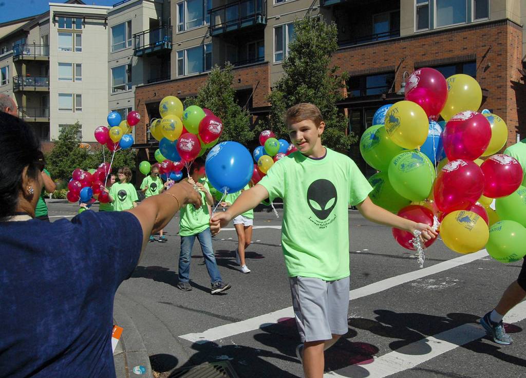 Spectators receive balloons with the Roanoke Inn logo at the &ldquo;Out of This World&rdquo; themed Summer Celebration parade on July 8. Katie Metzger/staff photo