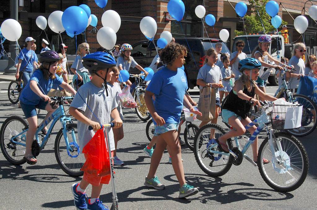 Kids ride bikes and carry balloons in the annual Summer Celebration parade on July 8, representing the Mercer Island Country Club&rsquo;s Silver Dolphins. Katie Metzger/staff photo