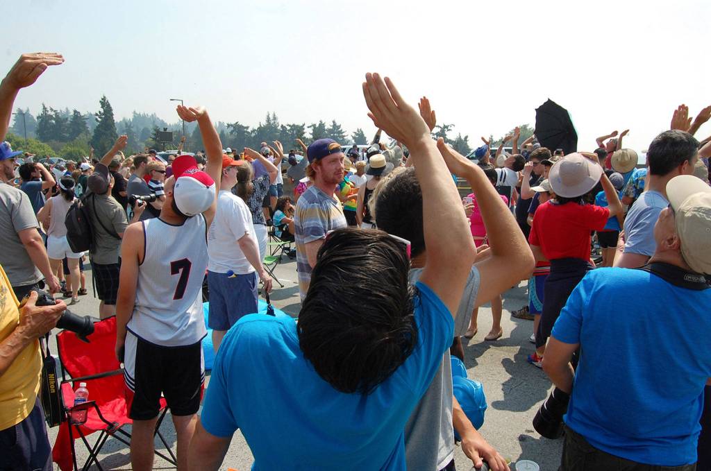 Spectators at Friday&rsquo;s Blue Angels air show practice shield their eyes to look for the planes in the sunny and hazy sky. Katie Metzger/staff photo