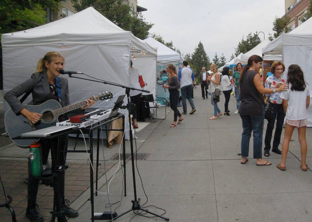 Mercer Island High School senior Sophie Feldman entertains the crowd at Art Uncorked as they make their way from &ldquo;Art Alley&rdquo; along 78th Avenue Southeast to the wine and beer garden in the Greta Hackett Outdoor Sculpture Gallery. Katie Metzger/staff photos