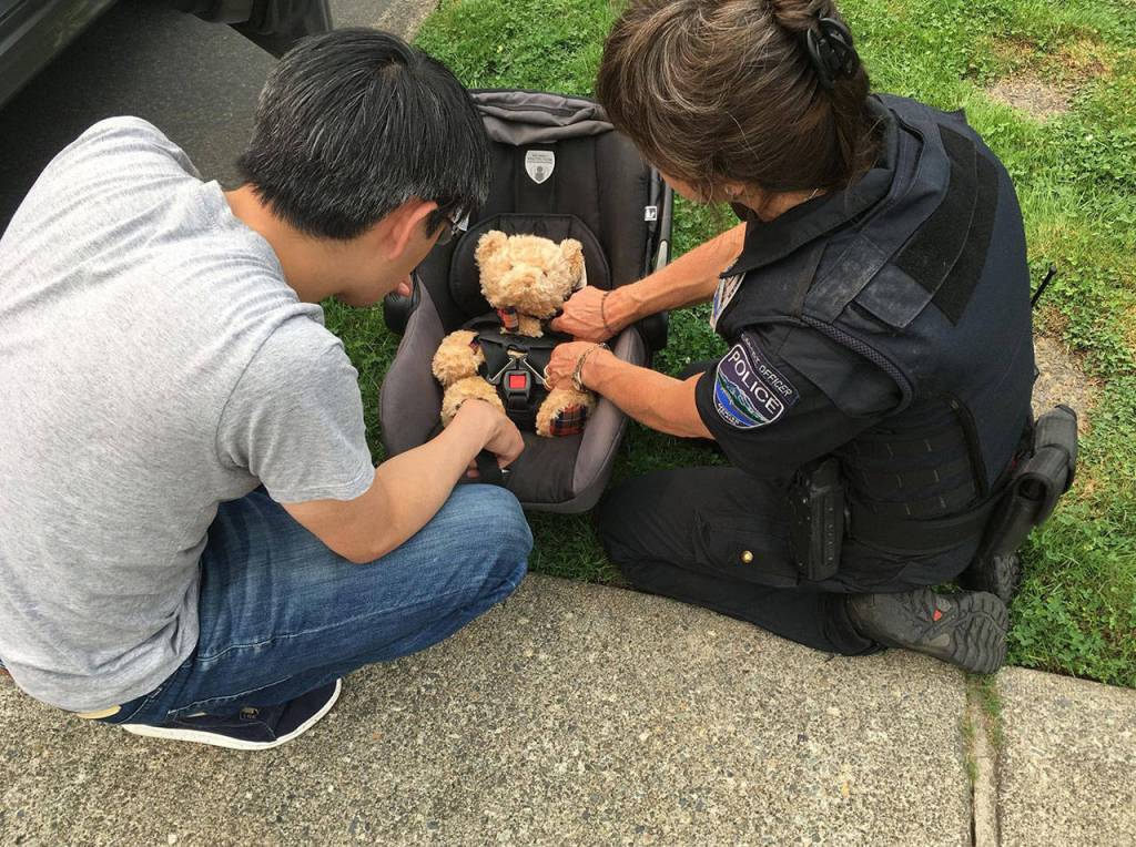 Mercer Island Police Department Support Officer Anna Ormsby helps teach father-to-be Trevor Wong how to install and use a car seat in his vehicle. Photo courtesy of MIPD
